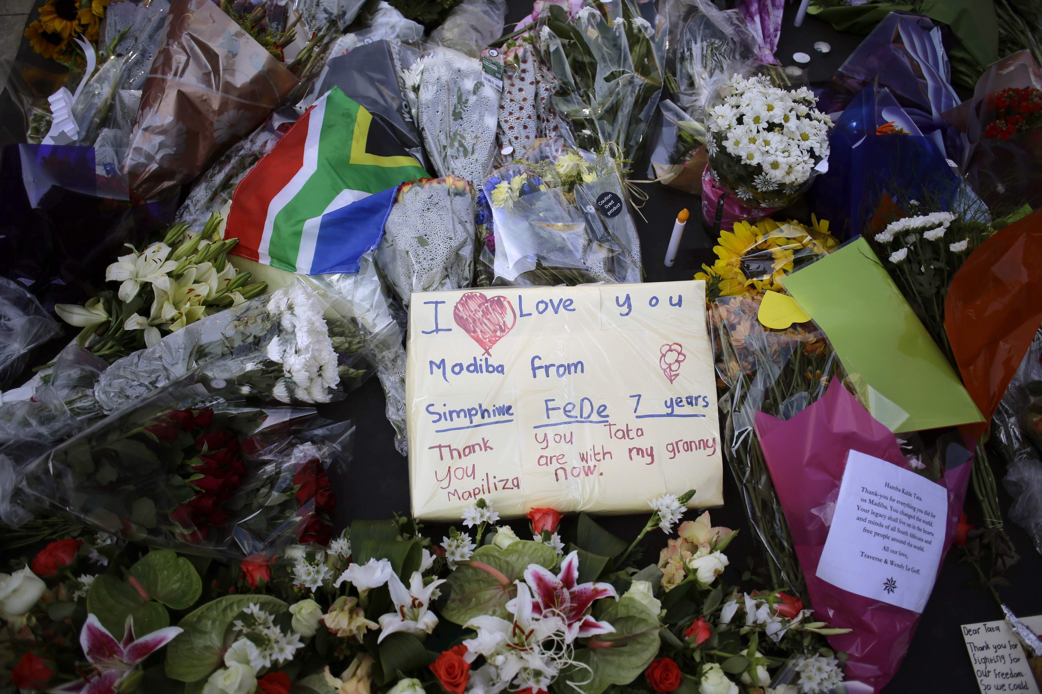 Flowers and written tributes are seen at Mandela square in Johannesburg