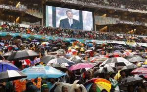 South Africans brave the rain as they listen to U.S. President Barack Obama speak during a memorial service for Nelson Mandela at FNB Stadium in Johannesburg