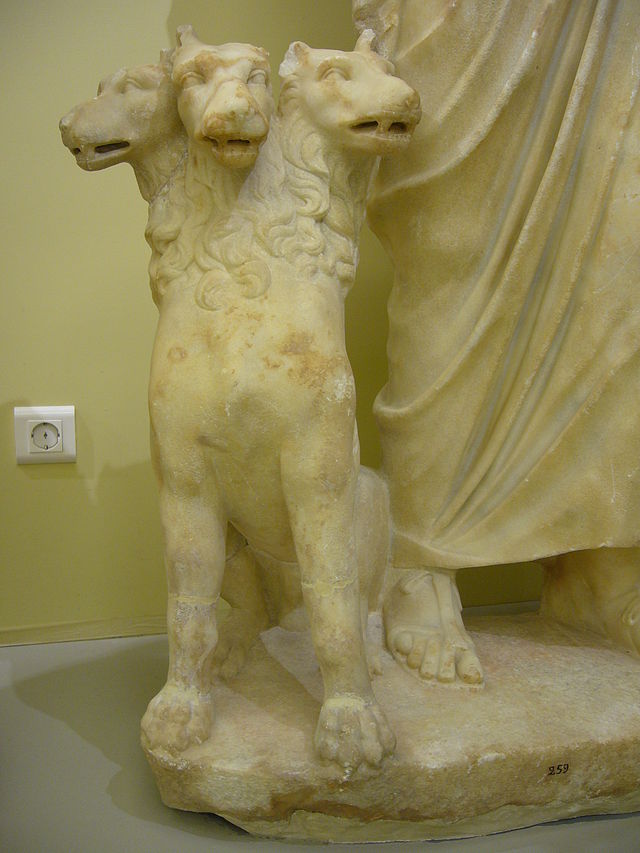 Detail of Roman sculpture of seated Hades, showing Cerberus. Image via Wikipedia.