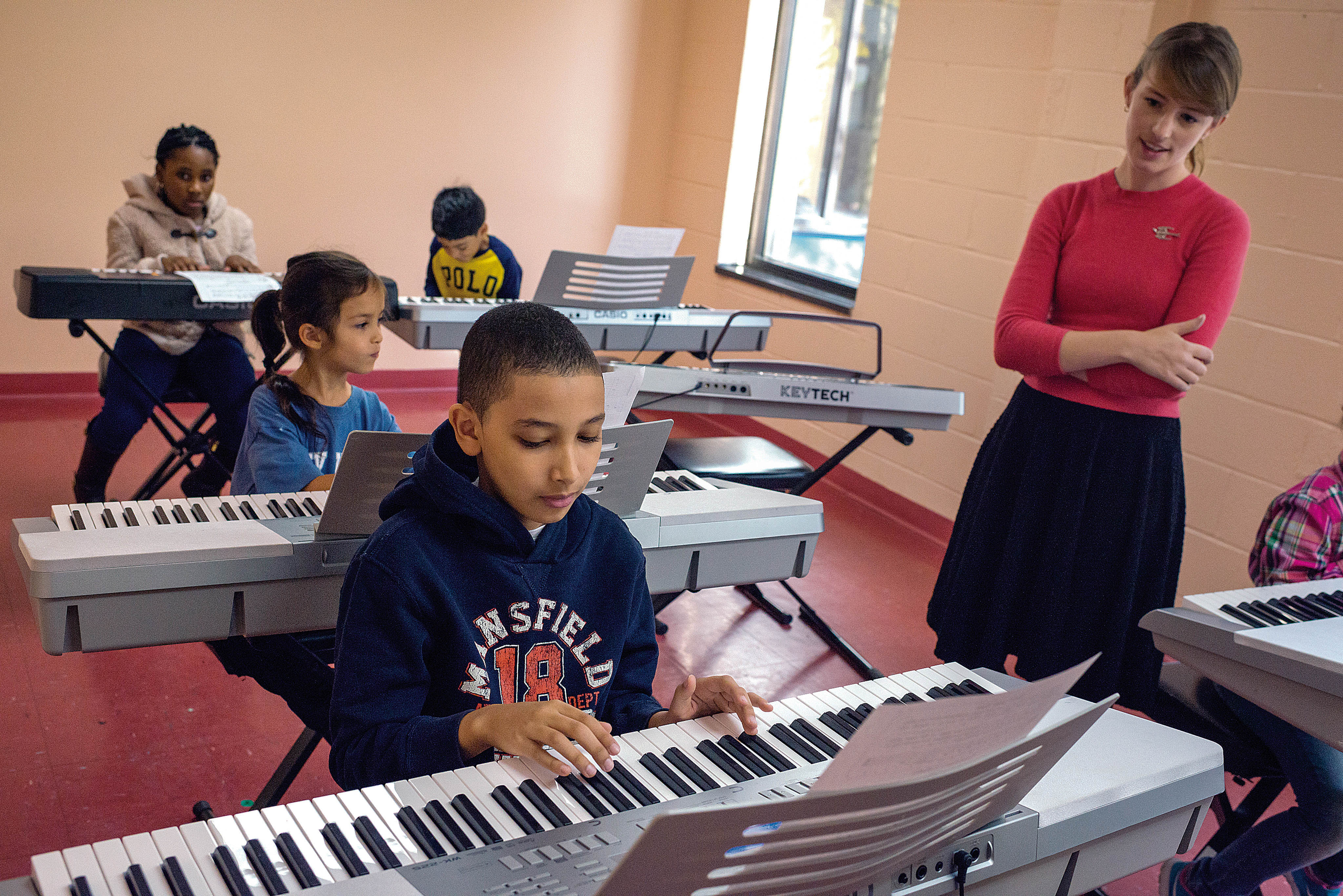 Photo by Adrian Fussell -- Students in a group piano class practice from sheet music at the Bronx House School for Performing Arts on Saturday.