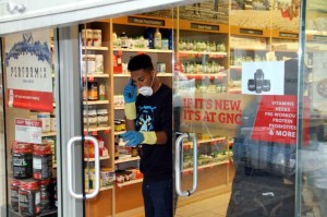 A worker takes a break from disinfecting a Jerome Avenue GNC after a pair of raccoons spent a day and-a-half running around the store .-- Photo by David Greene