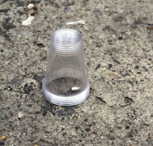 A plastic cup protects a shell casing left at the scene of a double shooting in Bedford Park. Photo by David Greene