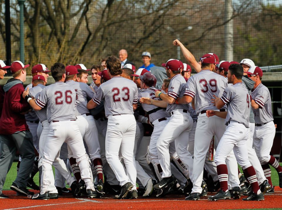 Fordham players mob Jason Lundy, celebrating his game-winning homer to win A-10 baseball game between St. Joseph and Fordham at Houlihan Park, in the Bronx, New York on April 13, 2017. (Credit Robert Cole). 
