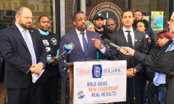 Brian Benjamin (at podium), candidate for State Senate, joins NYC Council Member Rory Lancman (left) to unveil a new three-point strategy for closing Rikers Island in three years as Akeem Browder (right) and advocates look on