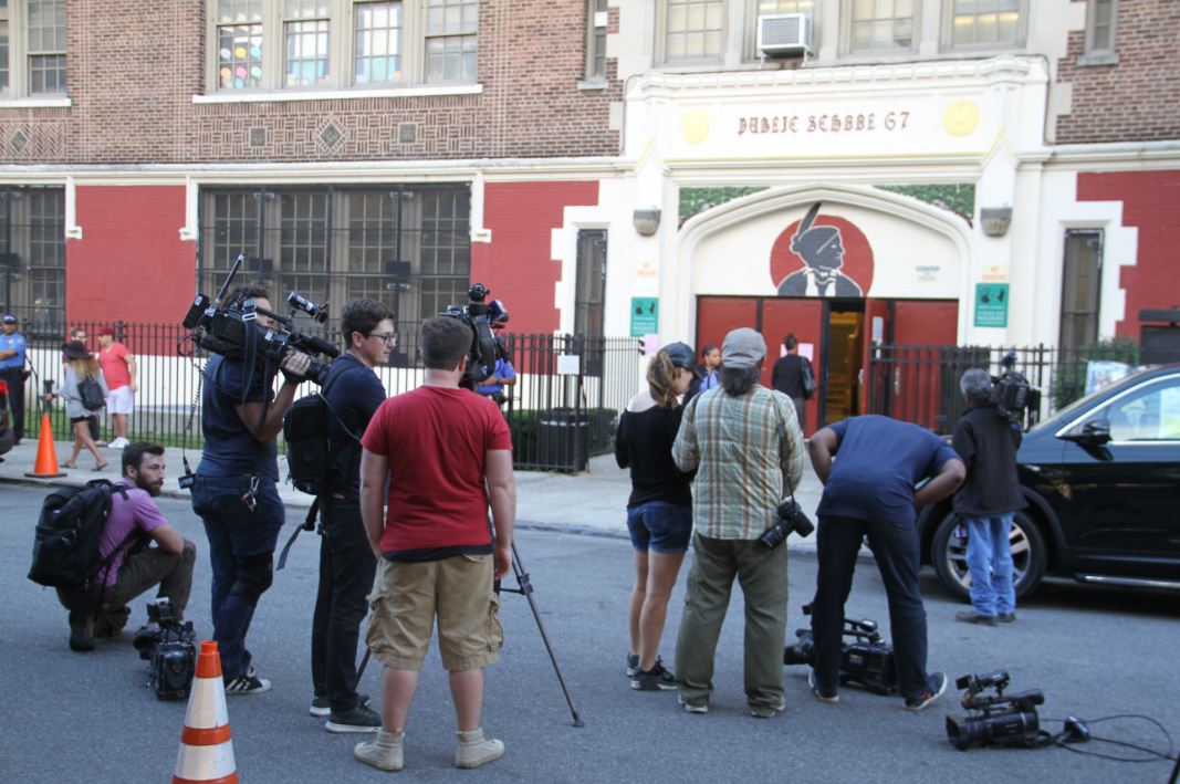  Broadcast journalists wait for Mayor Bill de Blasio come out after visiting the school a day after two teens were stabbed. Photo by David Greene