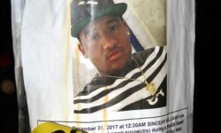 An NYPD wanted flyer is added to a pole with crime scene tape on it, outside of Maestro's Caterers announcing a $10,000 reward for information in the shooting death of Sincear Williams, 16.--Photo by David Greene