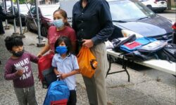 Councilman Gjonaj with a mother and her two children with their new book bags, and some face masks the councilman was also handing out.